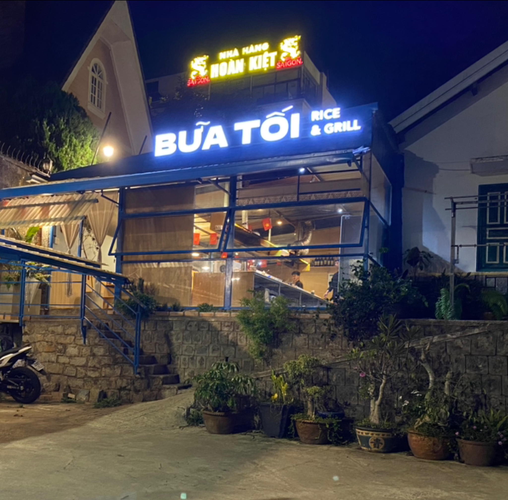 Bàn ăn gỗ sáng đèn vàng tại BỮA TỐI Đà Lạt.